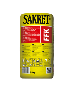 SAKRET FFK flexible gray tile adhesive being applied with a notched trowel for floor tiling.